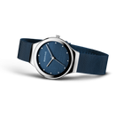 Wristwatch displayed at an angle, dark blue mesh band extended, showing navy dial and silver-tone case.