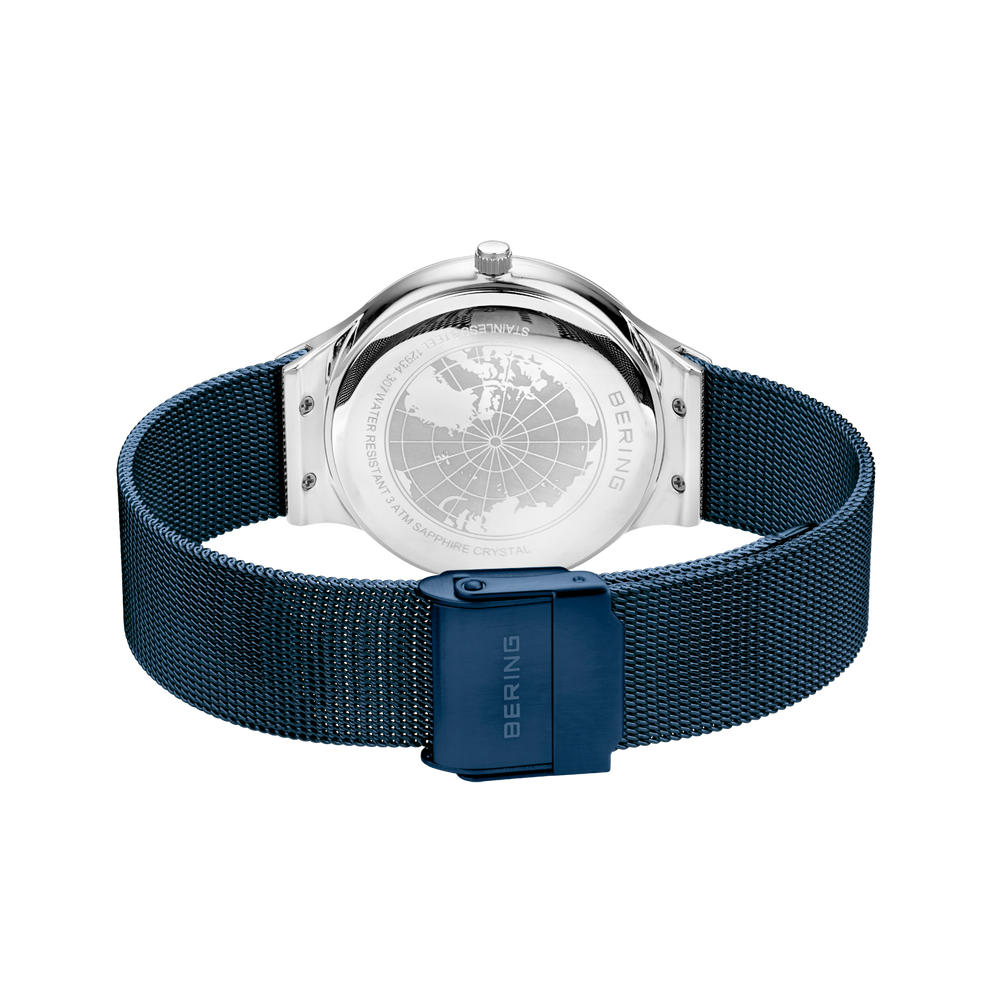 Watch displayed from back, showing transparent caseback with visible mechanism and teal mesh metal bracelet.