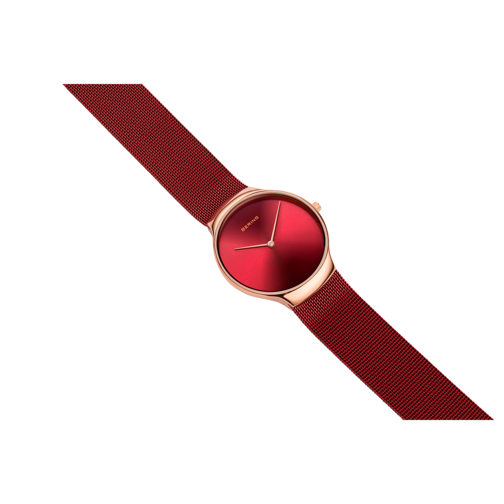 Burgundy woven-strap watch with rose-gold case and red dial, positioned diagonally