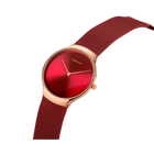 Wristwatch with rose gold case, deep red dial, and burgundy mesh band shown at an angle.
