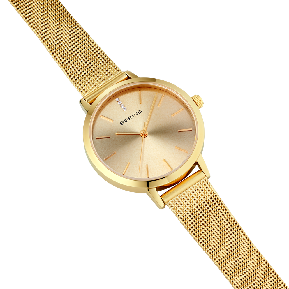 BERING wristwatch with round gold case, cream dial, and gold mesh band.
