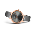 Montre or rose avec cadran gris foncé et bracelet maille, vue oblique