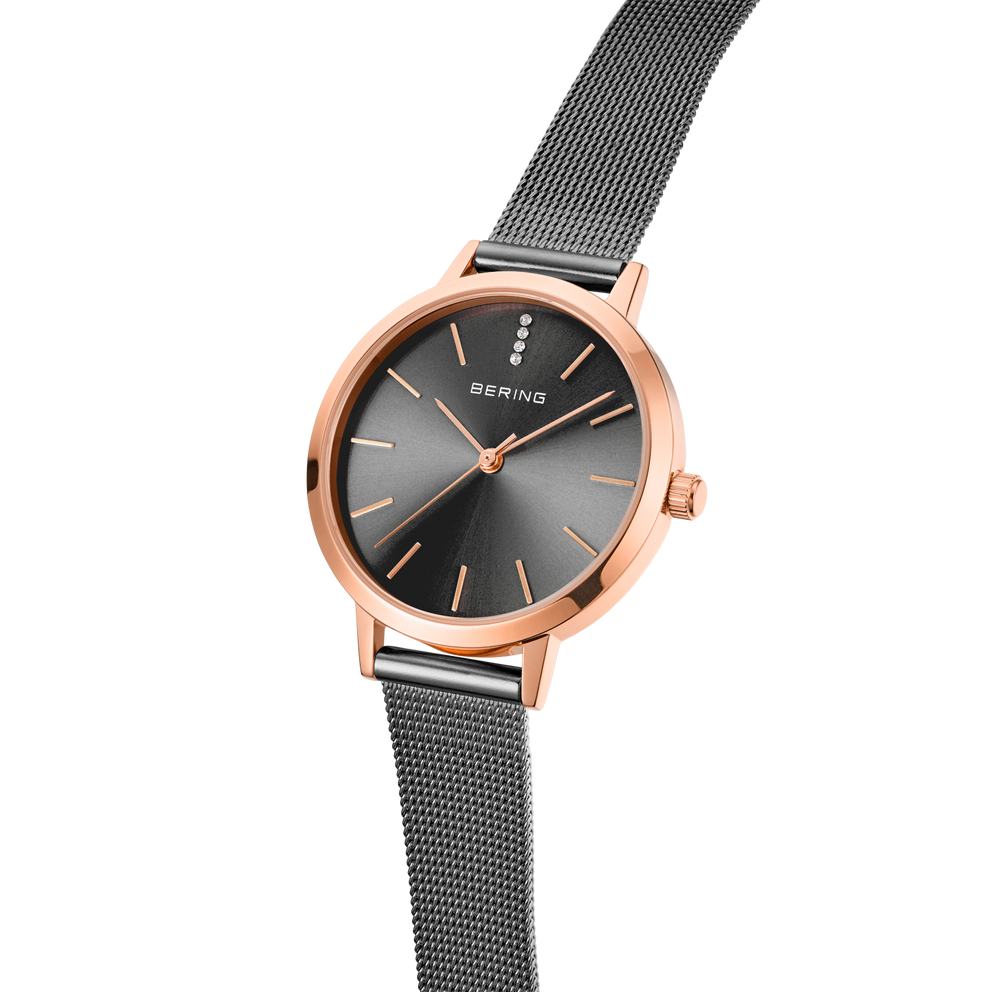 Montre BERING avec boîtier or rose, cadran gris anthracite et bracelet maille noire, vue trois quarts