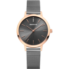 Montre BERING avec boîtier en or rose, cadran gris foncé, index minimalistes et bracelet en maille grise.