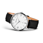 Montre BERING en vue trois quarts. Cadran blanc avec chiffres arabes, boîtier rond poli, bracelet cuir noir doublé beige.