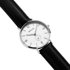 Montre au boîtier argenté, cadran blanc avec chiffres arabes, marquage BERING et bracelet noir en cuir, vue en angle.