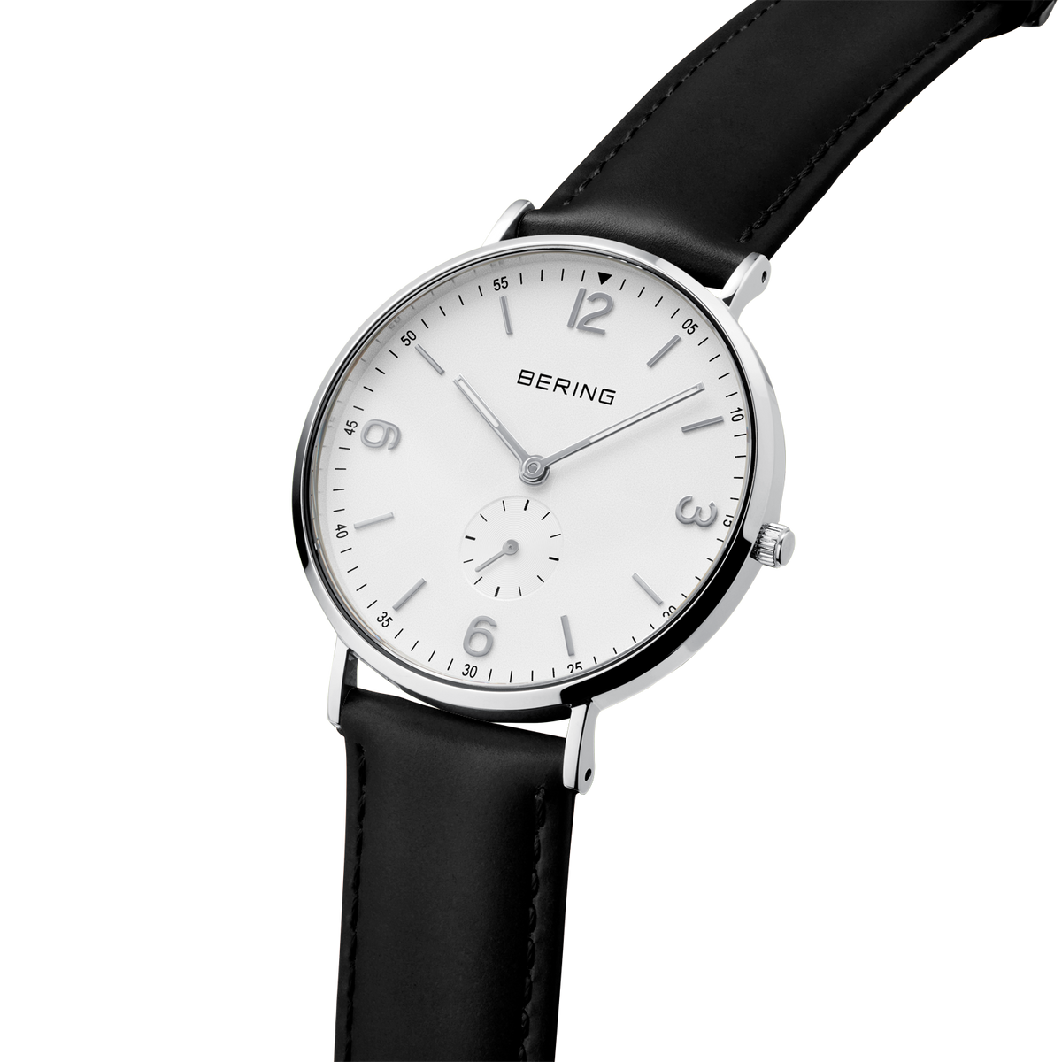 Montre-bracelet à boîtier rond argenté, cadran blanc avec chiffres arabes et bracelet cuir noir, vue de profil.