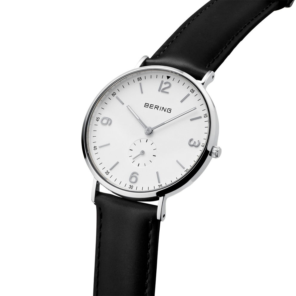 Montre-bracelet à boîtier rond argenté, cadran blanc avec chiffres arabes et bracelet cuir noir, vue de profil.