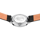 Montre avec boîtier rond argent et cadran blanc, bracelet caramel et boucles noires, vue de dessus.