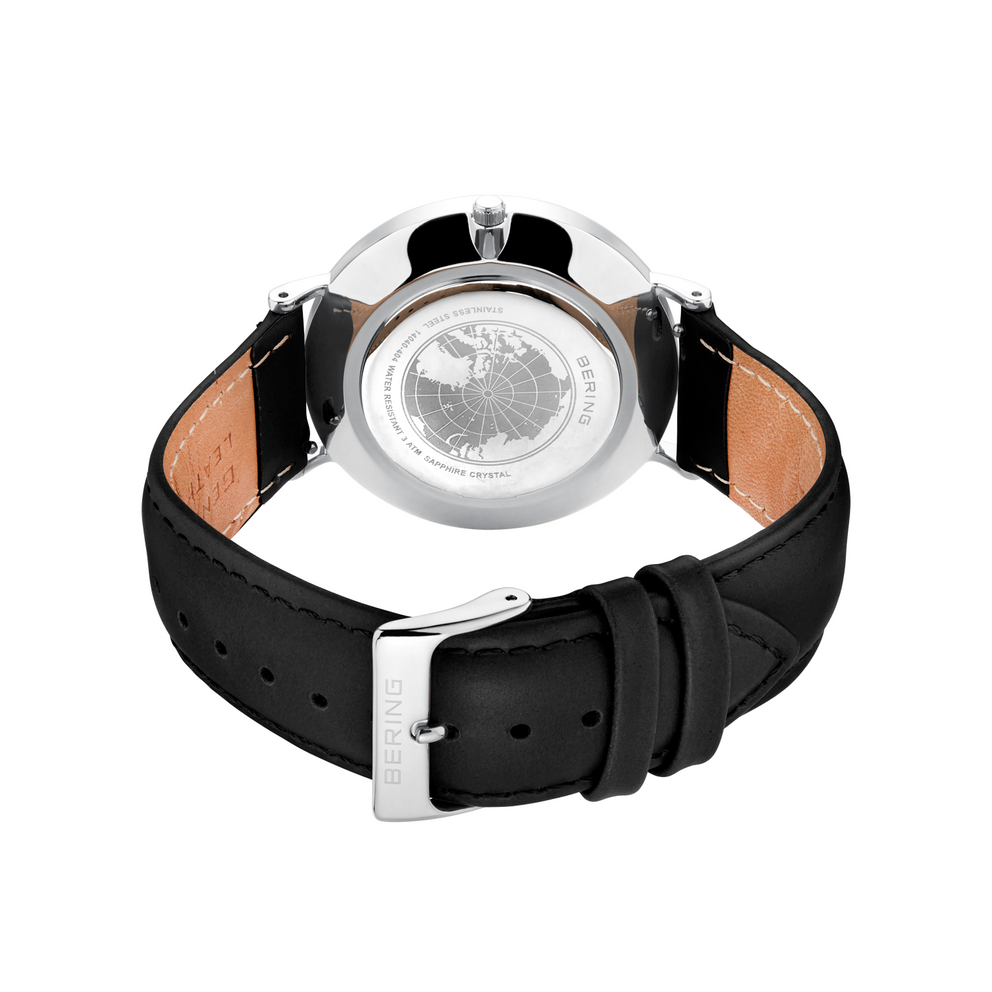 Vue arrière du boîtier de montre en acier poli avec bracelet cuir noir, doublure beige et fermoir métal.