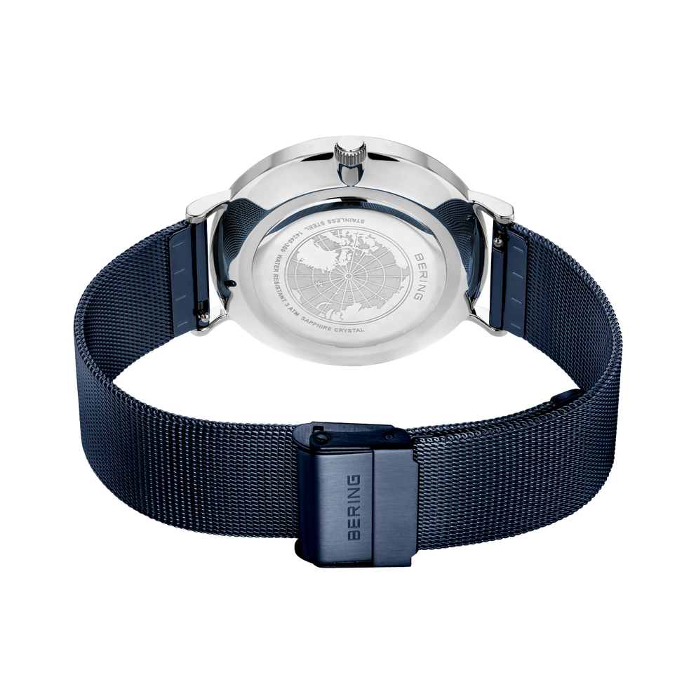 Achterkant van horloge met zilveren ronde kast en donkerblauwe stoffen band.