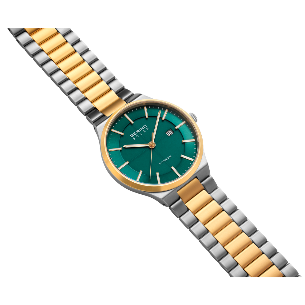 Reloj de pulsera con esfera azul-verde, bisel dorado y pulsera bicolor de eslabones alternados de oro y acero.