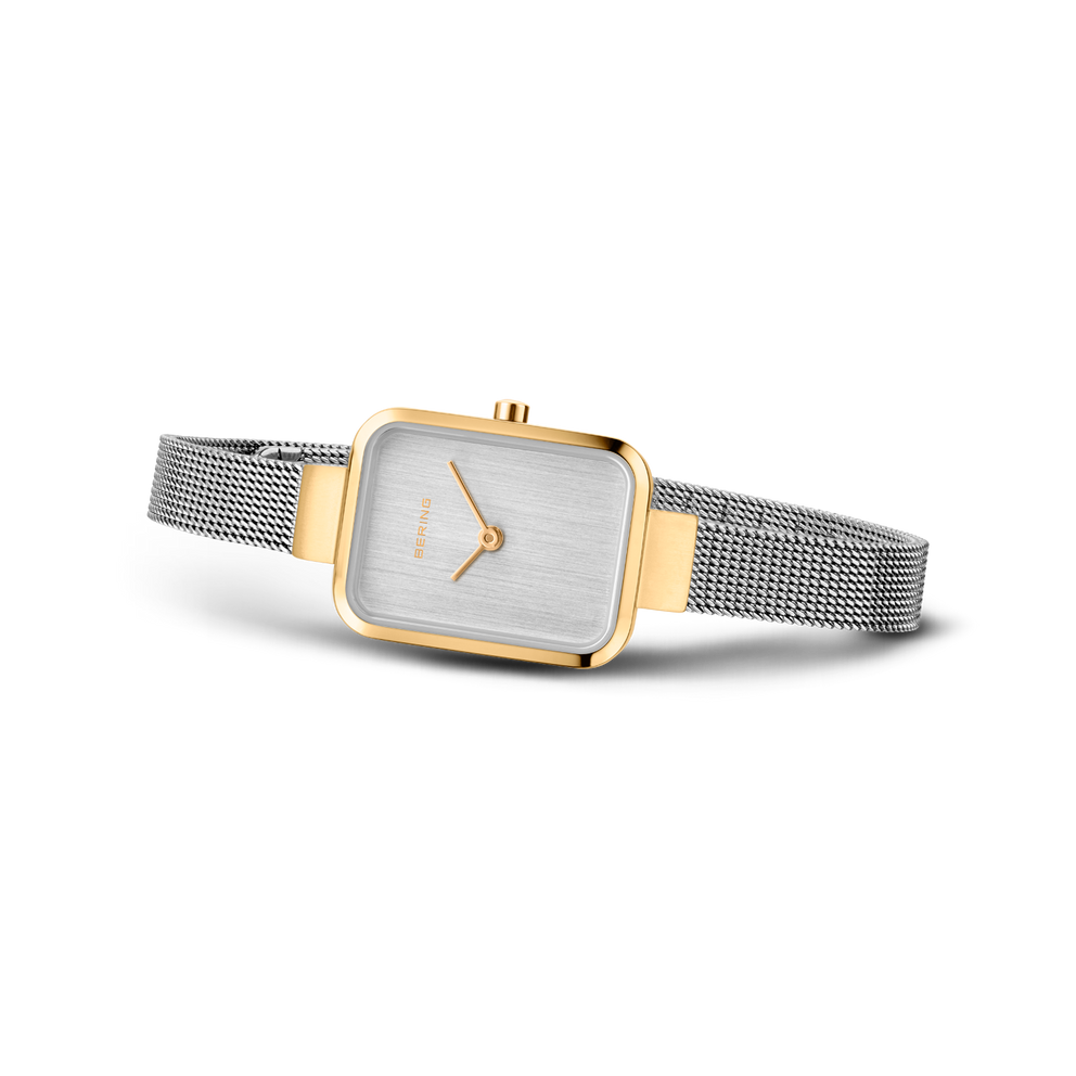 Square-face wristwatch with silver dial and gold-tone bezel, fitted with silver mesh band.