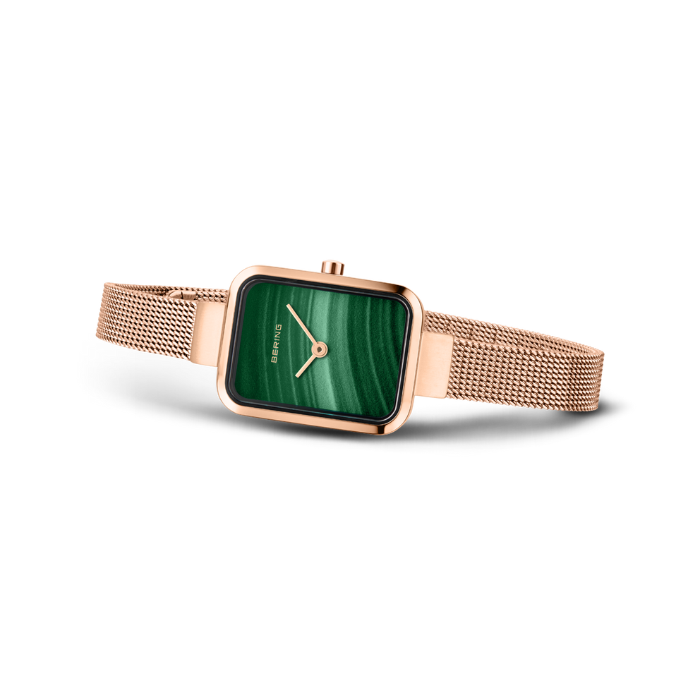 Reloj rectangular con esfera verde y pulsera malla en oro rosa, fotografiado de lado