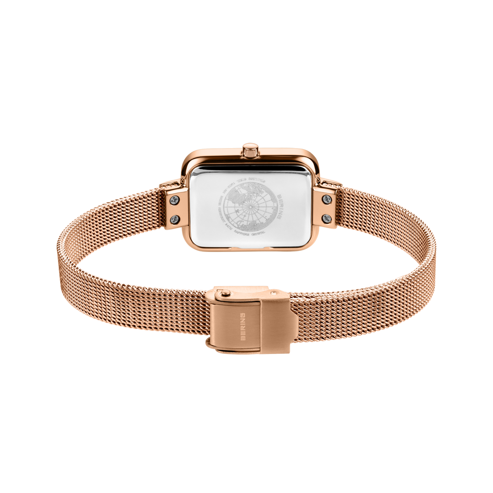 Reloj con pulsera malla en oro rosa, caja cuadrada y esfera blanca, vista superior con cierre magnético visible.
