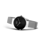 Reloj de pulsera BERING llevado en ángulo mostrando esfera negra, agujas blancas y pulsera de malla.