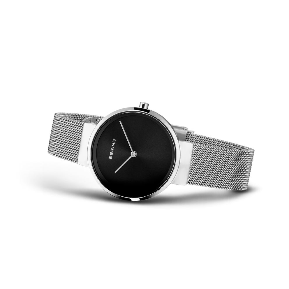 Reloj de pulsera BERING llevado en ángulo mostrando esfera negra, agujas blancas y pulsera de malla.