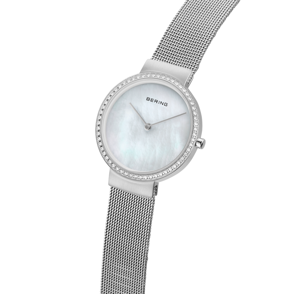BERING Armbanduhr mit silberfarbenem Mesh-Armband und rundem Zifferblatt mit kristallbesetzter Lünette, Schrägansicht