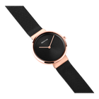 BERING wristwatch with round black dial, rose gold case, and black mesh band, shown at angled perspective.