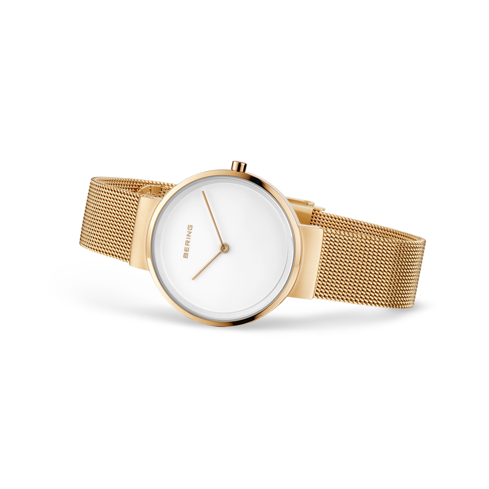 Reloj de pulsera redondo con esfera blanca y correa mesh dorada, fotografiado de lado
