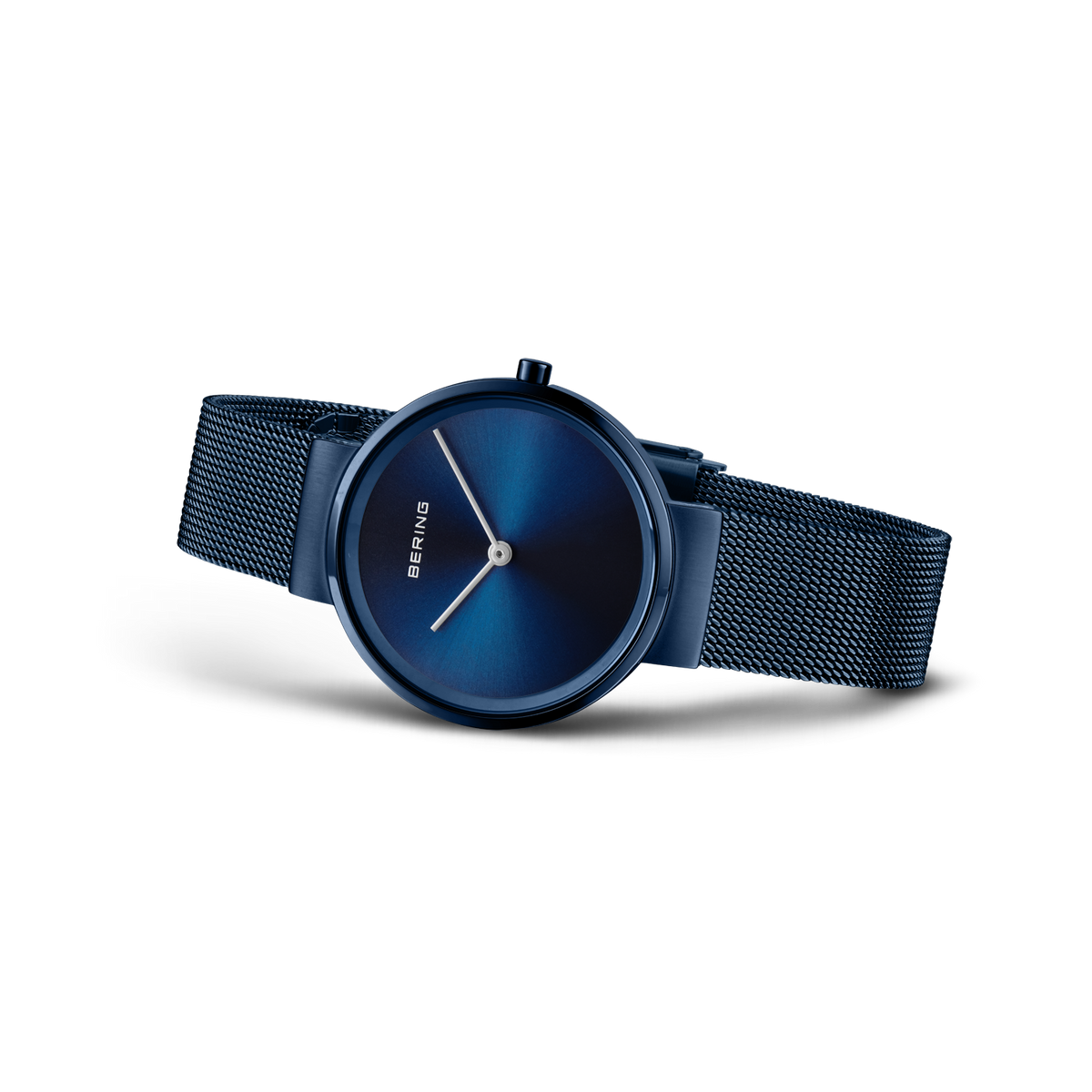 Reloj de pulsera con esfera azul redonda, manecillas delgadas, pulsera de malla oscura, vista en ángulo.