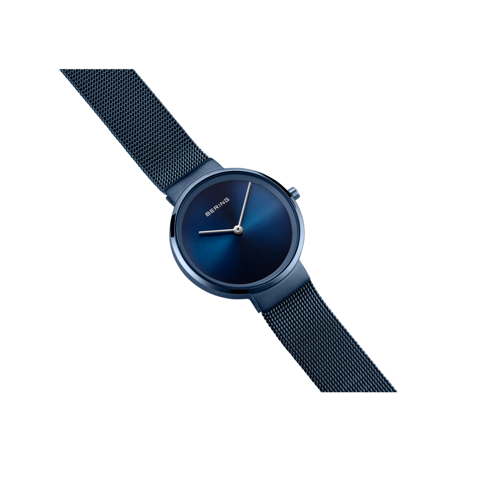Reloj de pulsera BERING con esfera azul oscuro, agujas plateadas y correa de malla, vista diagonal