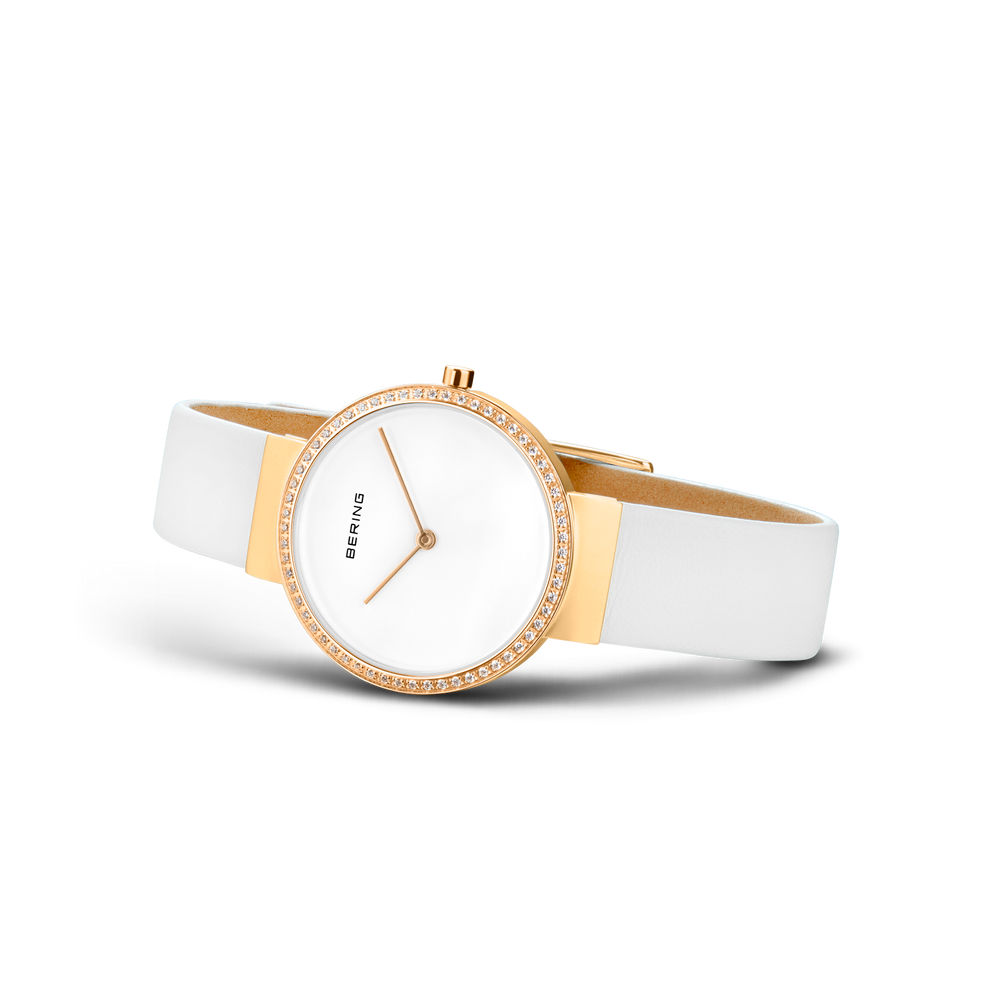 Orologio da polso con quadrante bianco, cassa oro rosé e lunetta perlinata, fotografato in angolo con cinturino bianco