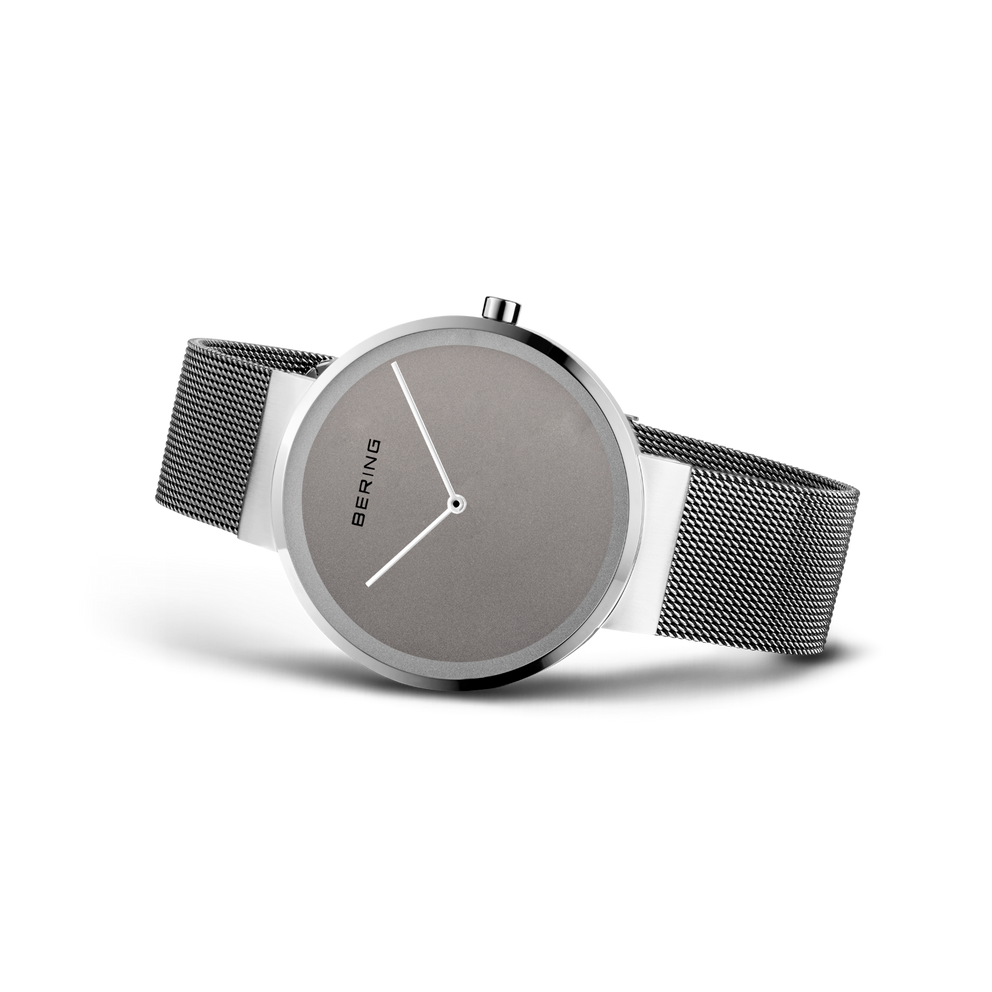 Reloj BERING en ángulo mostrando esfera gris, correa de malla metálica y caja plateada