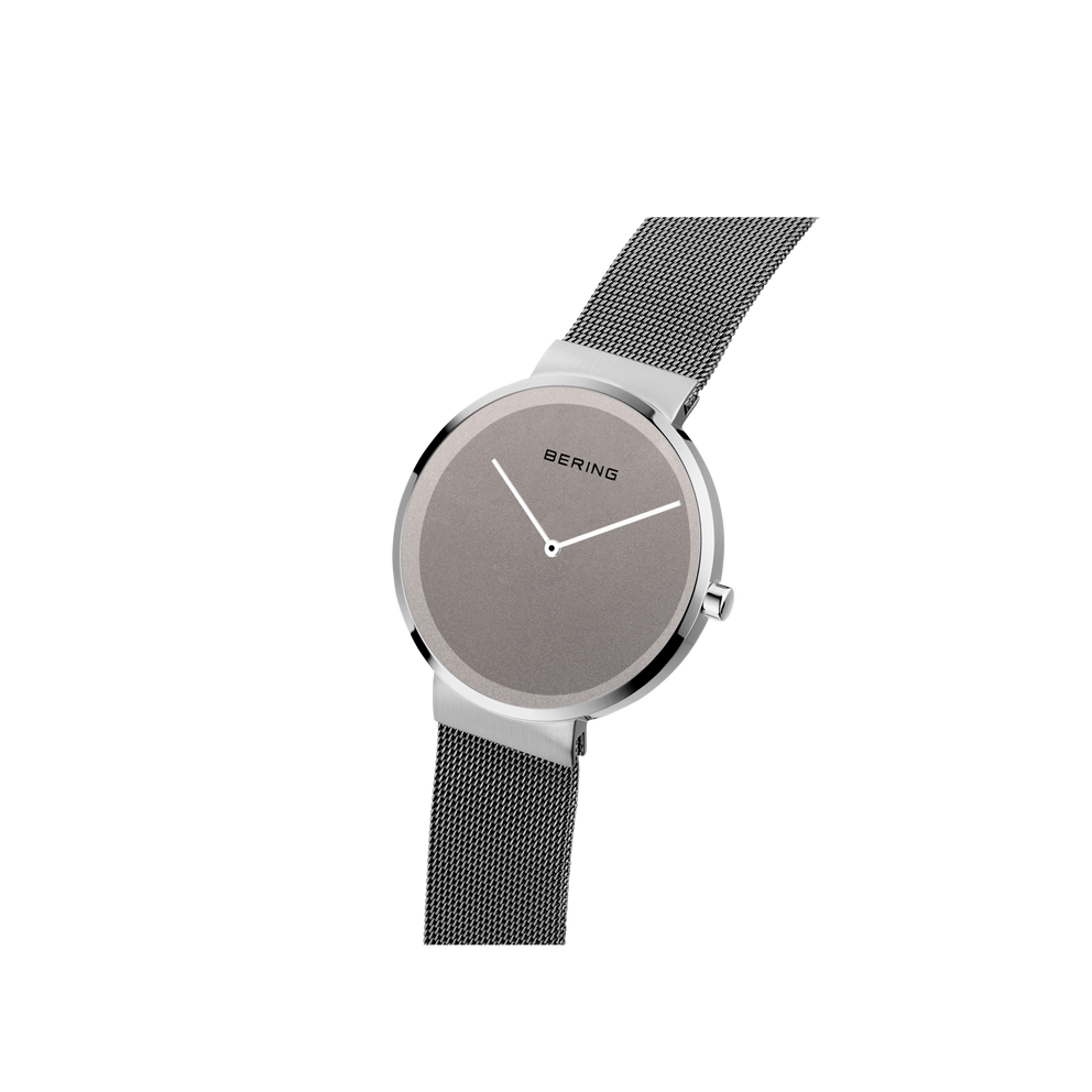 Reloj BERING vista de lado en ángulo con correa de malla extendiéndose de la caja y esfera gris