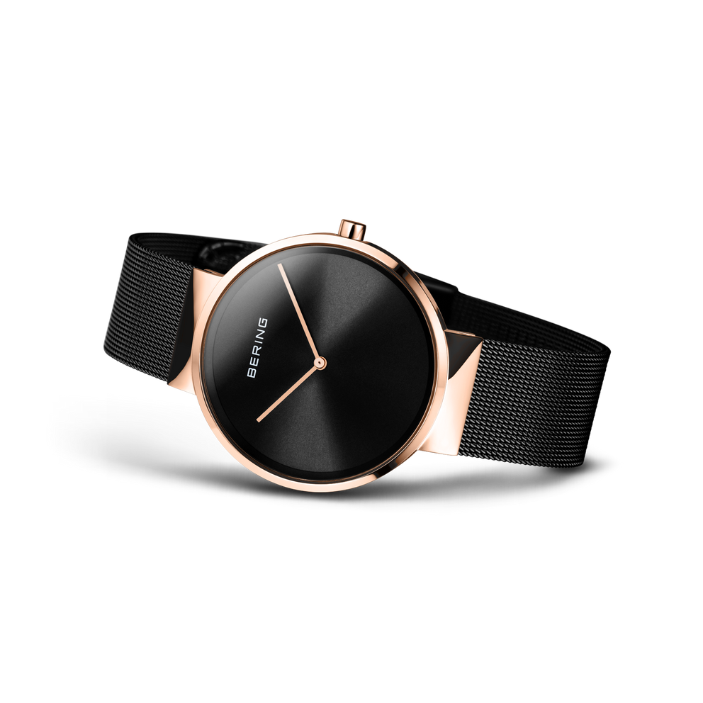 Orologio Bering con quadrante nero, cassa in oro rosa e cinturino a maglie nere, visto da angolazione tre quarti