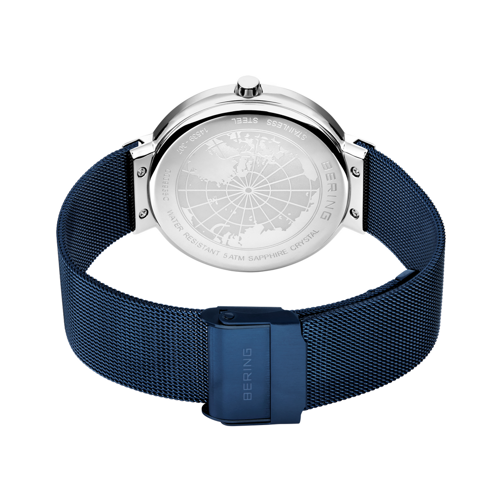 Vista posteriore dell'orologio con cassa in acciaio e cinturino mesh blu scuro.