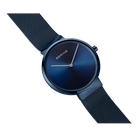 Reloj BERING con esfera redonda azul marino y correa textil de malla, vista angular.