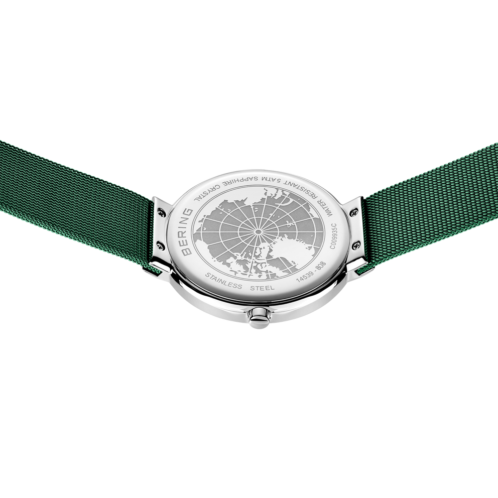 Orologio con cinturino in tessuto verde, fotografato dall'alto con quadrante a mappa mondiale