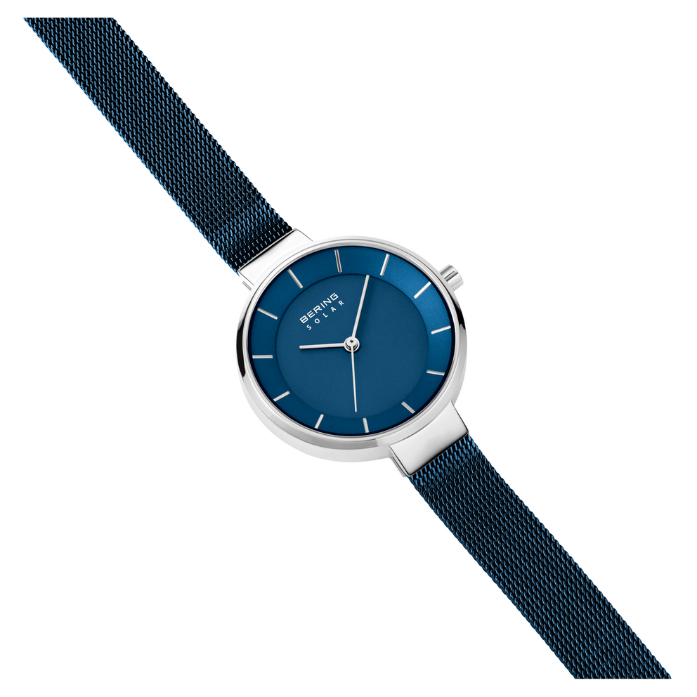 Orologio BERING con quadrante blu scuro rotondo, cassa argentata e cinturino mesh scuro in diagonale.