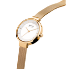 Round watch in champagne gold with white dial and textured mesh band, shown at three-quarter view.