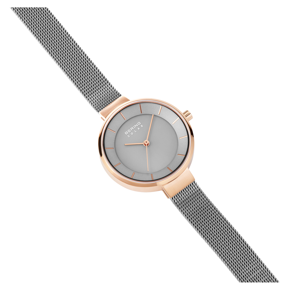 Watch with rose-gold case, grey dial, and dark grey mesh band, shown at side angle.