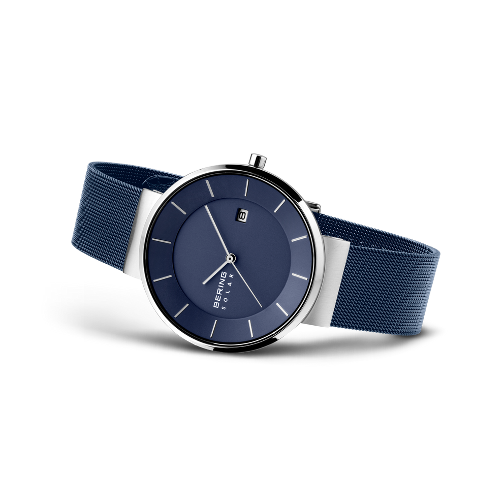 Montre avec cadran bleu foncé, boîtier argenté et bracelet maille bleu marine, vue latérale