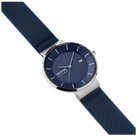 Montre au cadran bleu marine et boîtier argenté, bracelet textile structuré, vue en angle