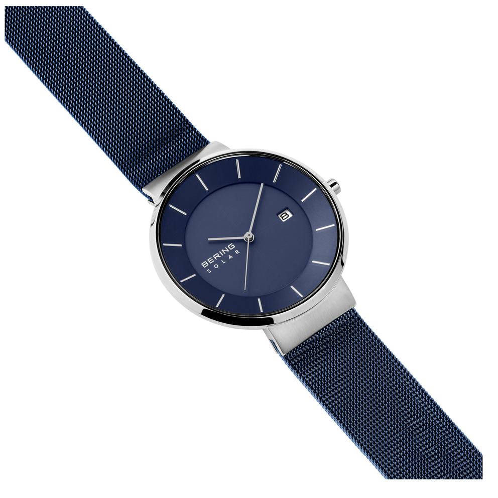 Montre au cadran bleu marine et boîtier argenté, bracelet textile structuré, vue en angle