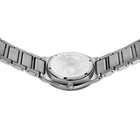Reloj fotografiado desde atrás con pulsera de acero y fondo visible