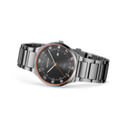 Reloj BERING con esfera negra y bisel rose doré, mostrado en ángulo con pulsera de eslabones metálicos