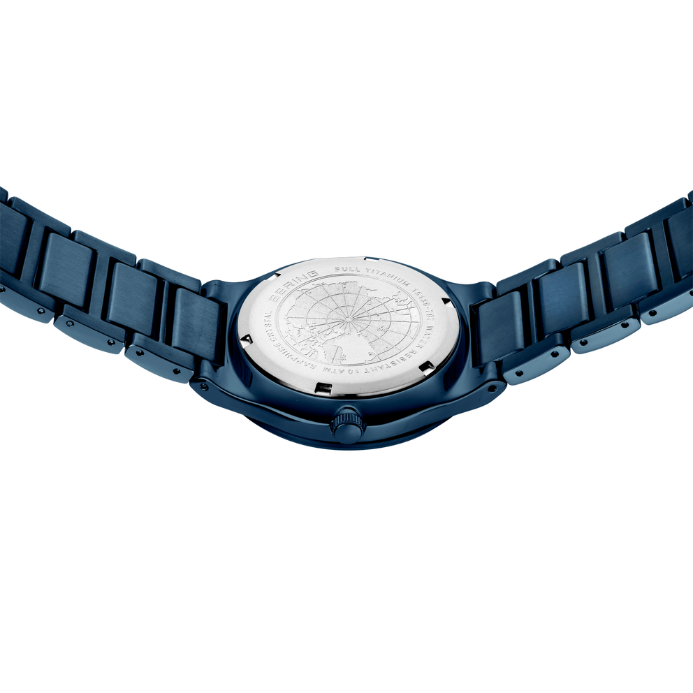 Zilvergekleurde horloge-achterkant met gegraveerd motief, omgeven door donkerblauw gesegmenteerd bandje
