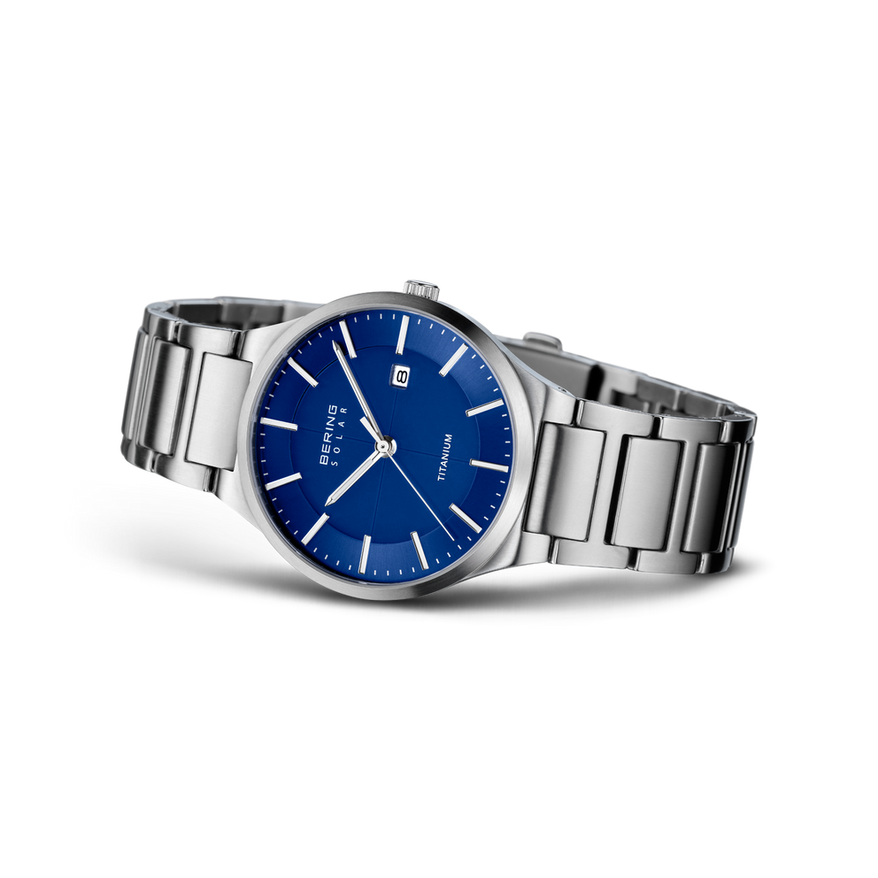Stainless steel wristwatch with deep blue dial, white bar indices and hands, metal bracelet shown at angle.