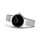 Watch at three-quarter angle showing silver mesh band and black dial face