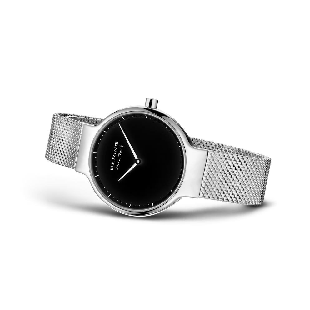 Watch at three-quarter angle showing silver mesh band and black dial face