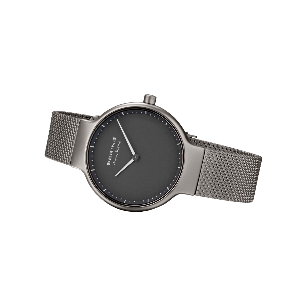 Minimalistische Uhr mit grauem Zifferblatt, einfachen Stundenmarkern und Mesh-Metallarmband, Frontalansicht.