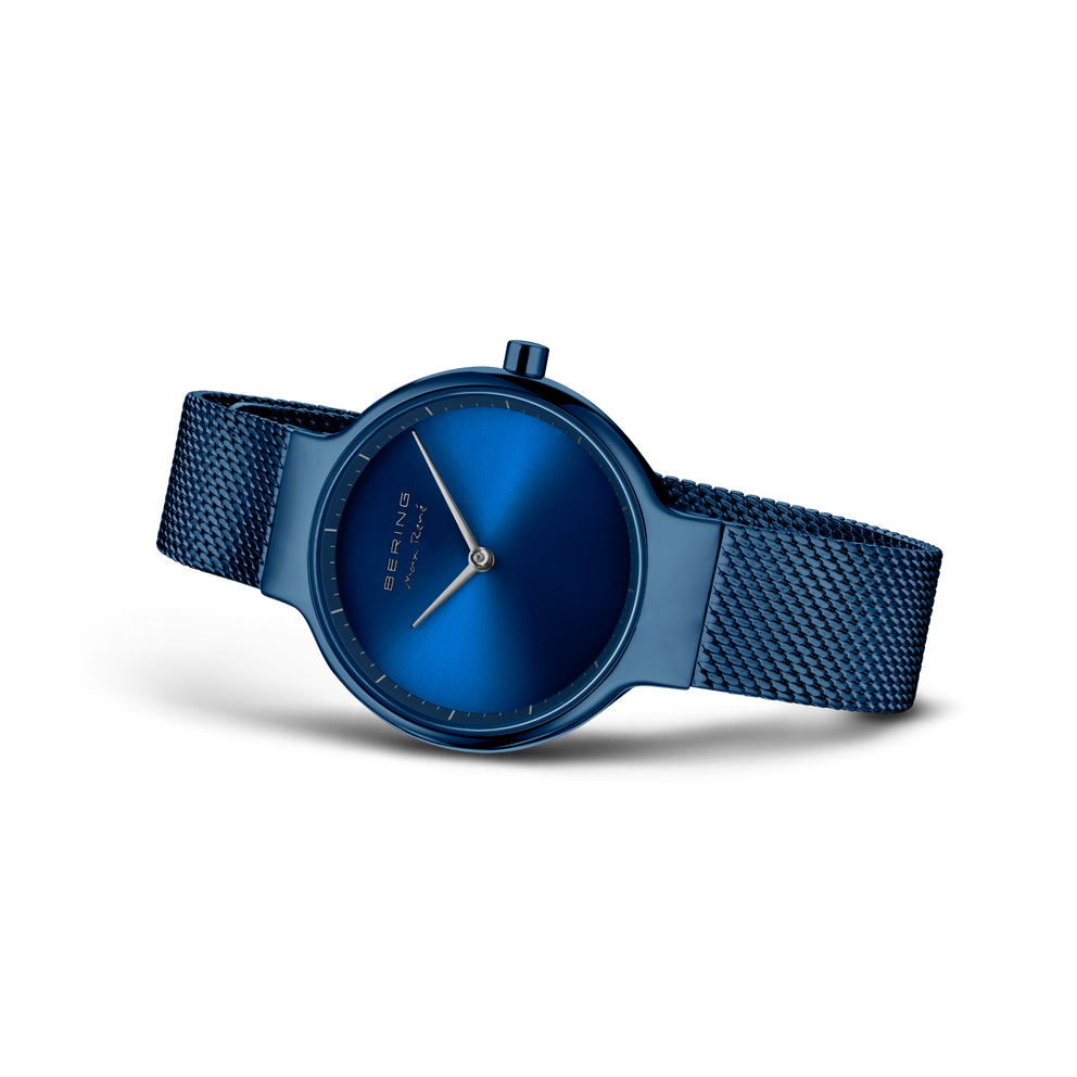 Blauw polshorloge met meshband, schuine hoek toont wijzerplaat en band.