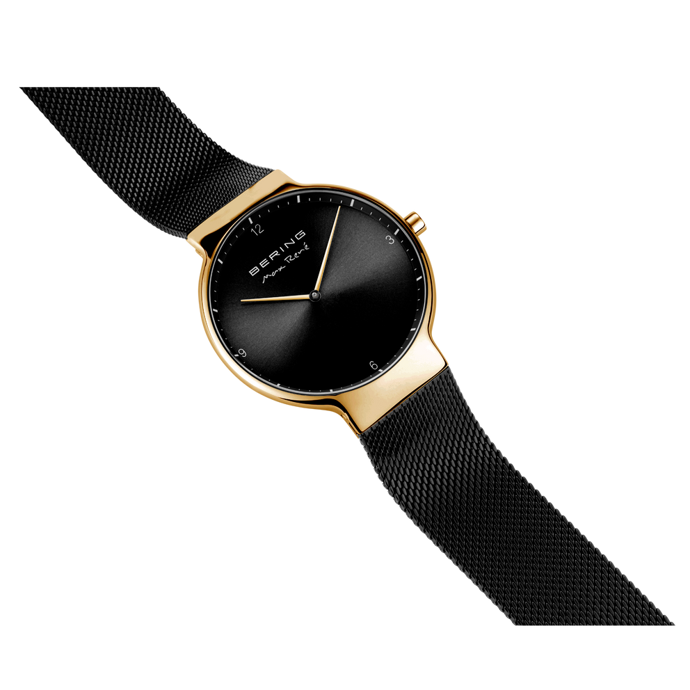BERING armbåndsur i guldfarve med minimalistisk sort urskive og sort mesh-strop, fotograferet fra siden