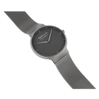 Orologio da polso con quadrante scuro e braccialetto a maglia metallica in angolazione.