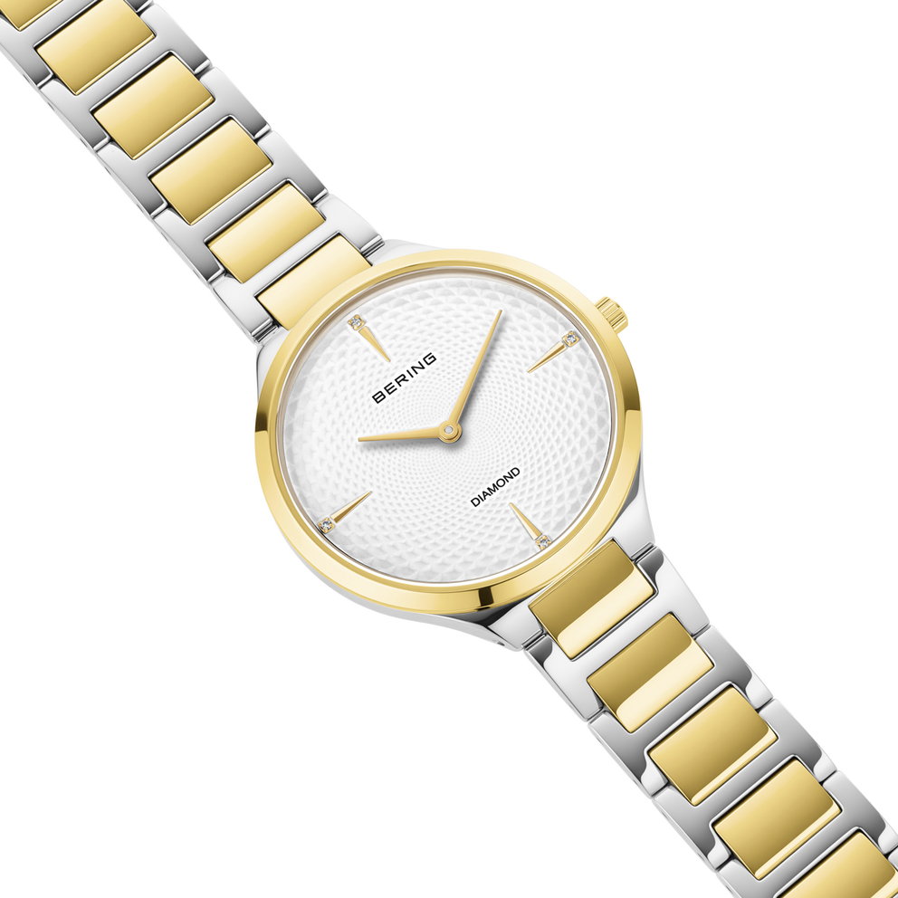 Orologio da polso BERING bicolore con bracciale oro e argento, quadrante bianco strutturato, mostrato completamente.